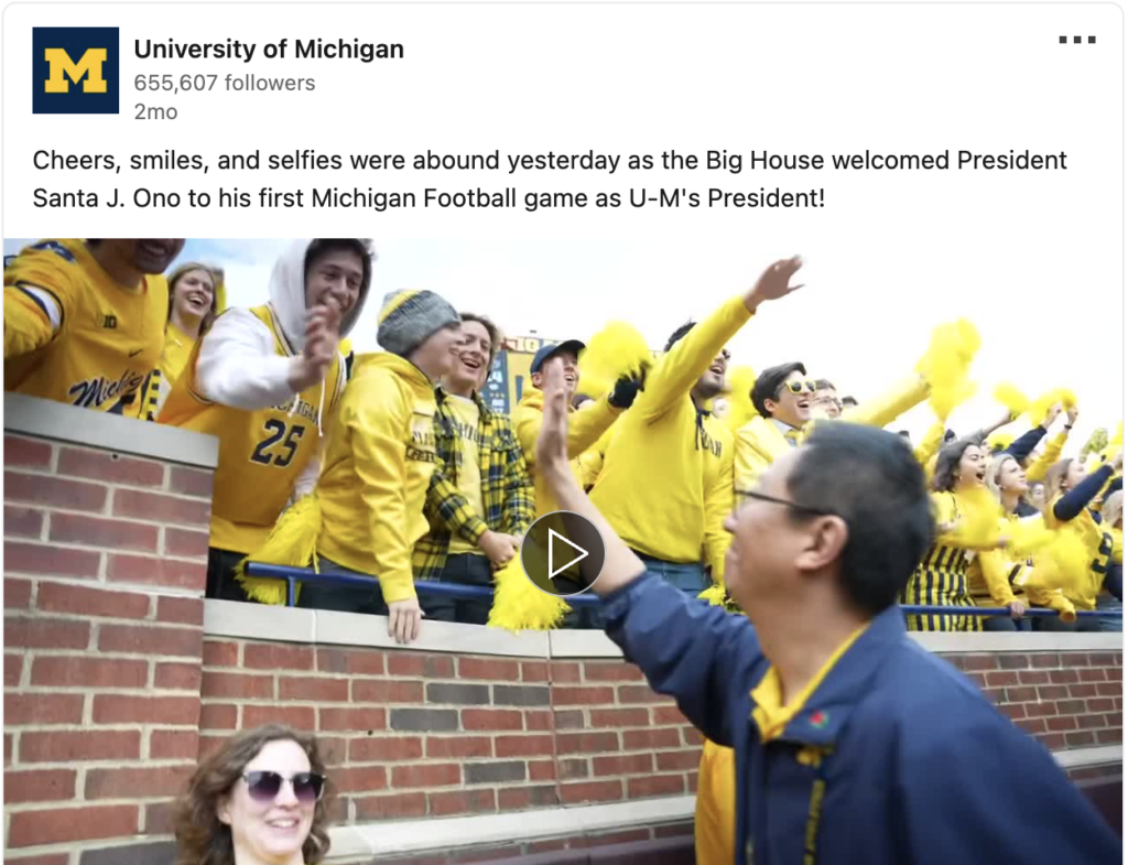 Video screenshot of President Ono high-fiving students at Michigan Stadium