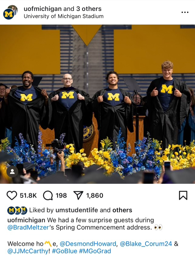 A screenshot of an Instagram post of four people standing on the commencement stage showing their Michigan shirts.