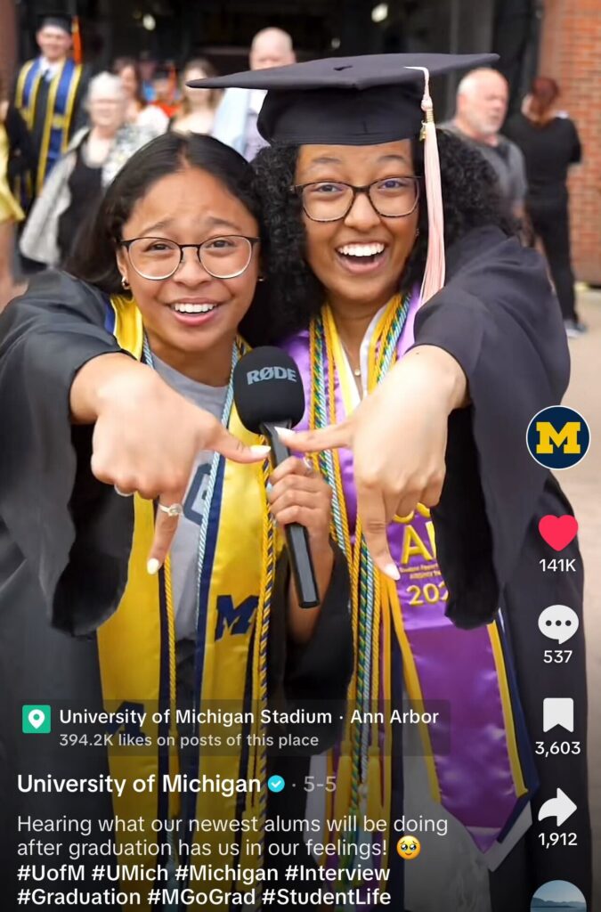 A screenshot of a TikTok showing two graduates with the caption reading "hearing what our newest alums will be doing after graduation has us in our feelings."